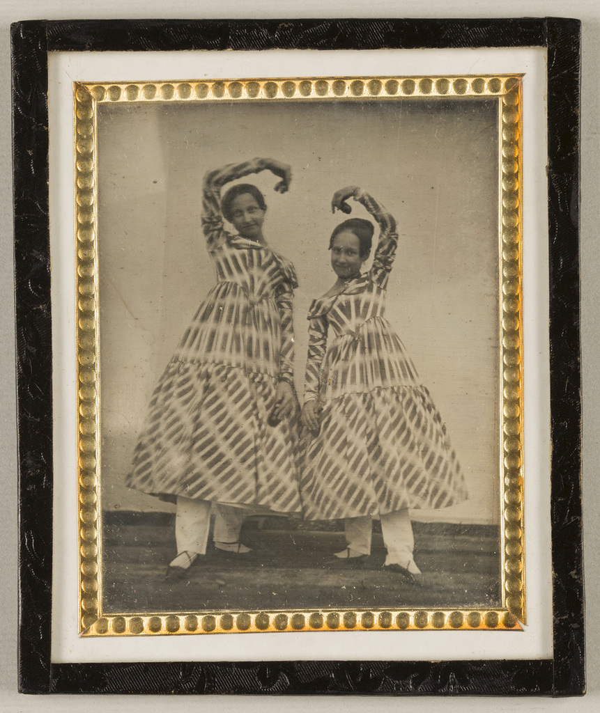 Portrait Of Two Girls In Striped Costumes Smiling Standing